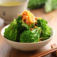 Green bumpy gourds with topping in a bowl, teacup, chopsticks