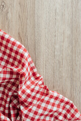 Obraz premium Red and White Checkered Tablecloth on Wooden Surface Background