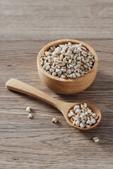 Natural Whole Grains in Wooden Bowl and Spoon on Rustic Table