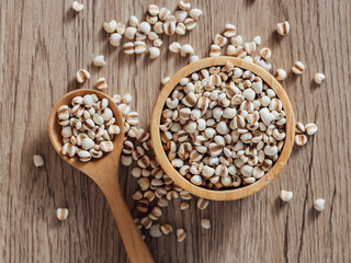 Dried Grains in Wooden Bowl and Spoon on Wooden Surface Background