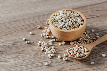 Organic Grains in Wooden Bowl with Spoon on Rustic Table Surface