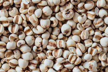Raw white grains of cereal with distinctive markings on the surface