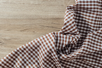 Brown and White Checkered Fabric on Wooden Surface Background
