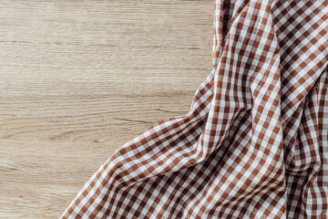 Brown and White Checkered Fabric Draped on Wooden Surface