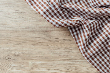 Brown and White Gingham Fabric on Light Wooden Surface Background