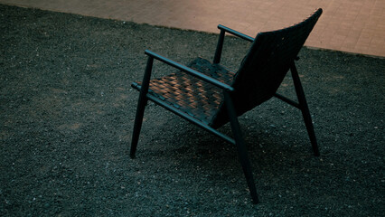 A black chair sits alone in a state of quiet and simplicity. A photographic work depicting the chair and emptiness.