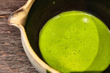 Close up of pure matcha green tea on wooden background