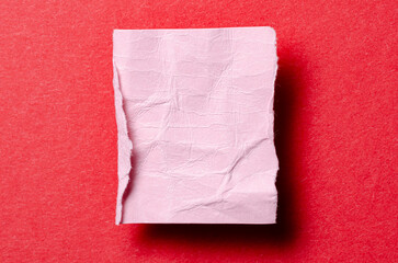 One single pink torn ripped wrinkled crumpled blank paper note with drop shadow, folded edge and copy space for text on background
