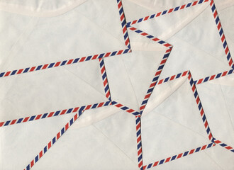 Vintage airmail envelopes arranged in a repeating pattern forming a textured postal paper background