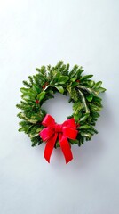 Festive Wreath Adorned with a Vibrant Bow: A beautifully crafted wreath, meticulously assembled with vibrant green foliage, is artfully enhanced with a striking red bow.