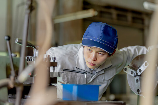 工場で機械を操作する男性作業員