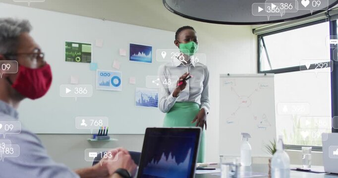 Animation of social media icons over african american woman wearing face mask giving a presentation