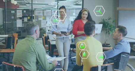 Animation of multiple icons over diverse coworkers discussing reports in office - Powered by Adobe