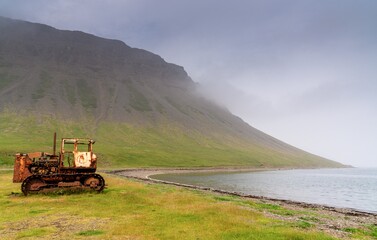Fototapeta premium old rusty caterpillar on the shores of the Westfjords in northwest Icleand near the village of Fossfjordur
