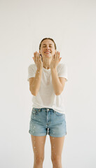 A woman looking refreshed splashing her face with water