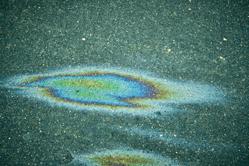 Oil Slick With Vibrant Colors on a Wet Asphalt Surface After Rain in an Urban Area During the Afternoon