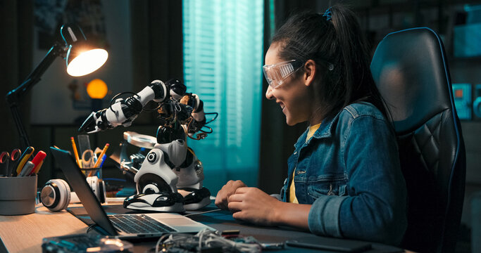 A child watches her robot closely, enjoying how it moves and lights up. The room glows blue in the night, creating a calming backdrop for this tech-focused evening activity.