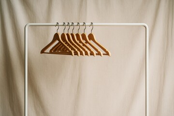 Wooden hangers on a minimalist white metal clothing rack against a beige fabric background, soft natural light, lifestyle organization concept. Ai generative
