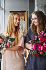 Mother and daughter with fresh flower bouquets