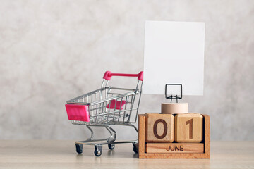 Shopping cart next to june 1 calendar with blank note
