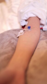 Medical professional with blue glove gently removes tape from cannula on arm. Patient arm remains ready for intravenous treatment. Precision and care during procedure. Important for health, recovery.