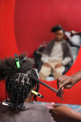 Afro young man with half braided hair viewed from behind with blurred mirror reflection