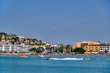 Beach with tourists enjoying activities near water at a sunny day in a coastal town