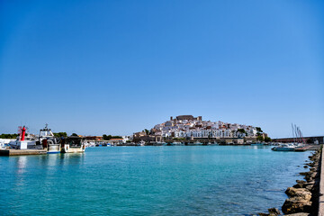 Fototapeta premium High view of a coastal town and harbor under clear blue sky on a sunny day in Spain