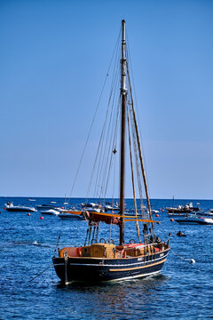 Sailing boat anchored in the sea with calm waters and other boats during daytime