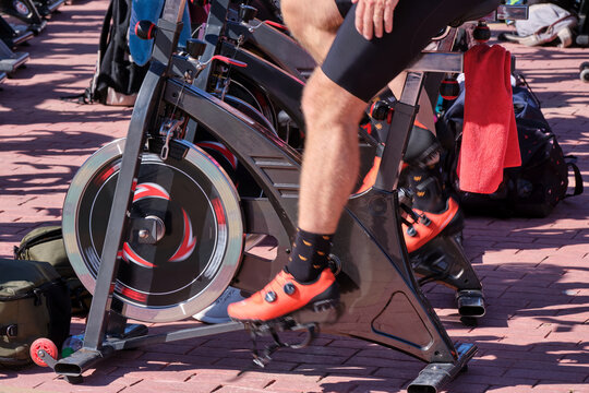 Cyclist engages in indoor cycling workout at fitness studio with focus on leg movement and equipment use