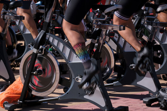 Cyclists participating in group spinning class during daytime at fitness event in urban setting