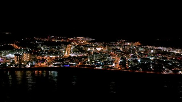Aerial view of vibrant Playa Las Americas lit for Christmas at night