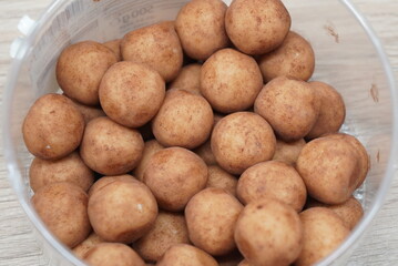 Close-up view of small, round potatoes with brown skin inside a clear plastic container