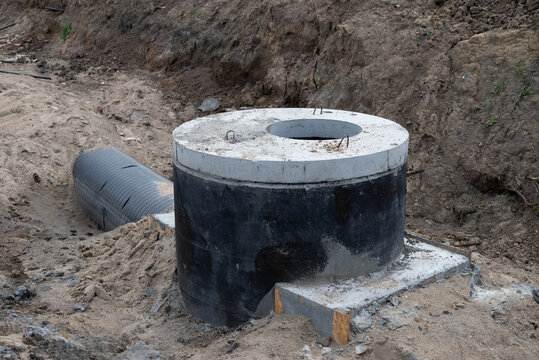 Construction of a concrete septic tank installation site in a residential area during daylight hours