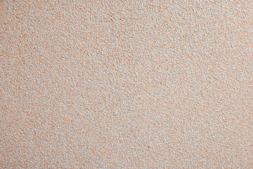 A textured beige wall background with a subtle grainy appearance. The surface is smooth and uniform, suitable for various design applications.