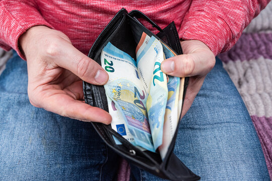 Man taking Euro banknotes out of black leather wallet close up, financial savings and payment