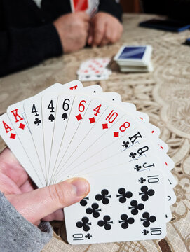Close-up of a person sitting at a table playing a game of cards
