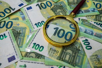 Magnifying glass on euro bills, finance analysis, audit, banking and business investigation concept