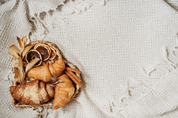 Croissants on heart tray on white cozy plaid