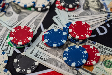 Colorful poker chips on US dollars background symbolizing casino games, winnings, luck and gambling concept