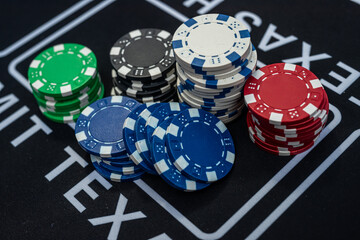 Stack of multicolored poker chips close up representing casino games, risk, gambling and betting concept
