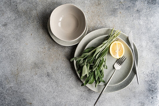 Overhead view of a place setting with fresh sage leaves and half a lemon