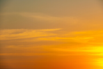 Dramatic golden sunset sky with vivid orange and purple clouds.beautiful twilight sky background with bright orange clouds during sunset.majestic evening sky with colorful cloudscape at golden hour.