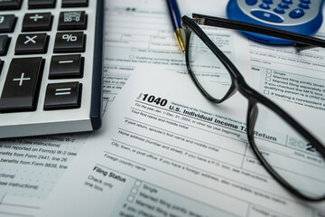 Form 1040 tax documents with calculator and fountain pen for 2025 financial filing