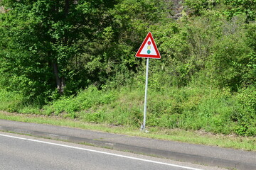 traffic lights warning sign in front of a curve