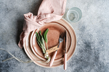 Overhead view of a rustic pink place setting with fresh sage leaves and a tag with the words Thank you