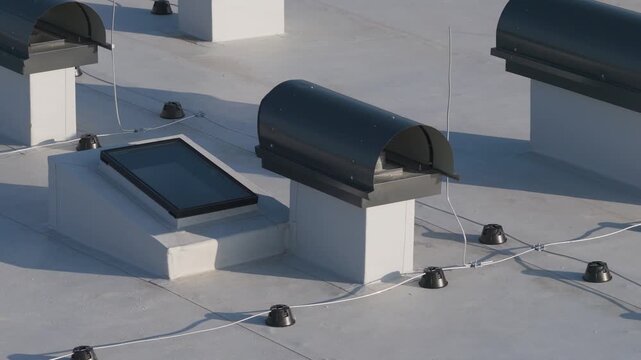 Close aerial view of apartment building roof with insulation, chimneys, lightning rod and technical installations.