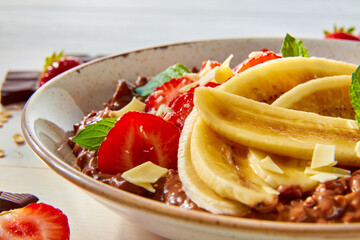Porridge mit Banane und Erdbeere in Schokolade