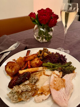 Close-up of a traditional British Christmas turkey dinner and a glass of champagne on a dining table