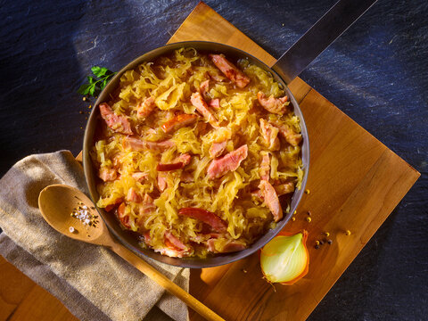  Sauerkraut mit Kasselerstreifen in Pfanne auf Holzbrett